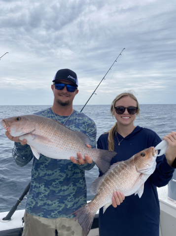 A Couple Holding Freshly Caught Fishes